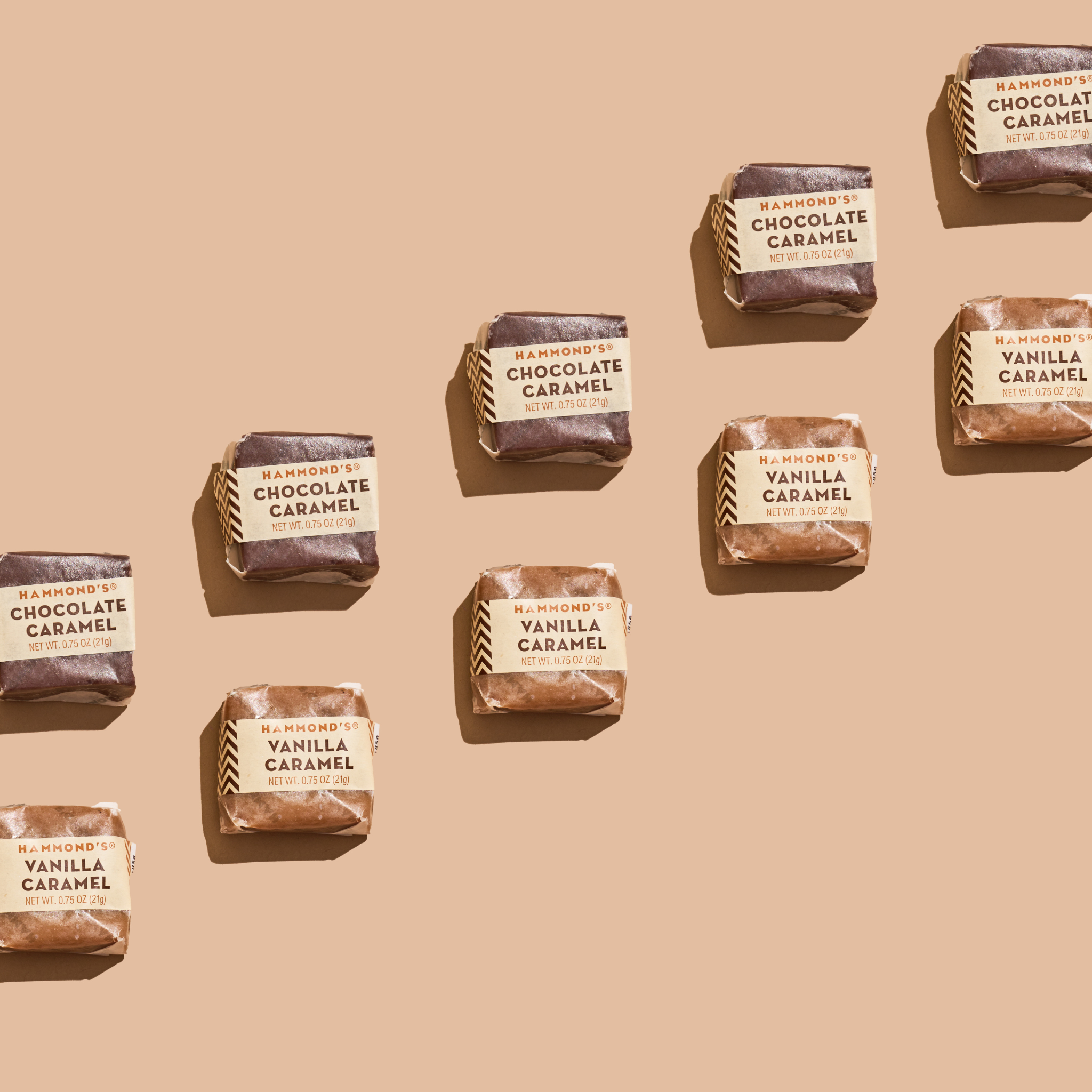 An array of individually wrapped Hammond's Chocolate Caramels displayed on a beige background.